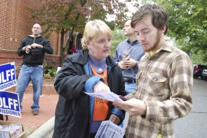Photo by Ava Barlow. Elisabeth Scott, a volunteer for the Orange County Democratic Party, gives a sample ballot highlighting the Democratic candidates to Will Hackney of Chapel Hill. Hackney was on his way in to the Carrboro Town Hall to participate in early voting Saturday.
